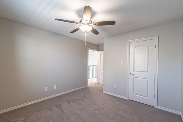unfurnished bedroom featuring carpet flooring, baseboards, and ceiling fan