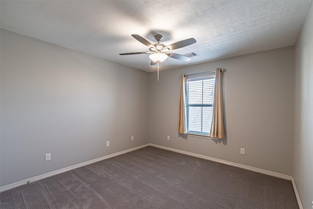 unfurnished room featuring visible vents, baseboards, dark carpet, a textured ceiling, and a ceiling fan