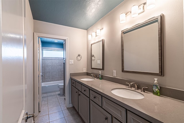 full bathroom with a sink, a textured ceiling, double vanity, and tile patterned flooring