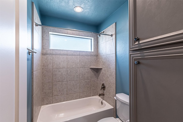 full bathroom featuring tub / shower combination, a textured ceiling, toilet, and a textured wall