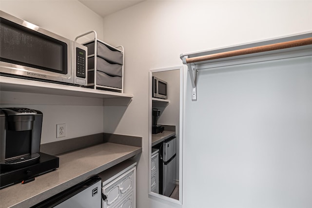 kitchen with white cabinetry, stainless steel microwave, and dark countertops