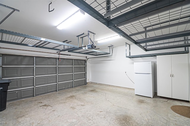 garage featuring a garage door opener and freestanding refrigerator
