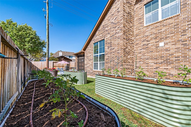 exterior space with a garden and a fenced backyard