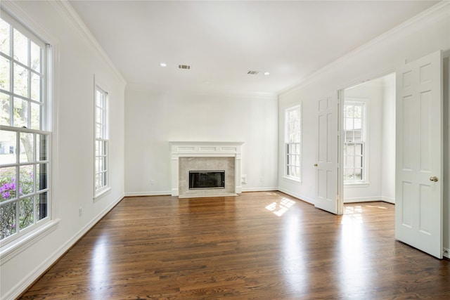 unfurnished living room with crown molding, a healthy amount of sunlight, and visible vents