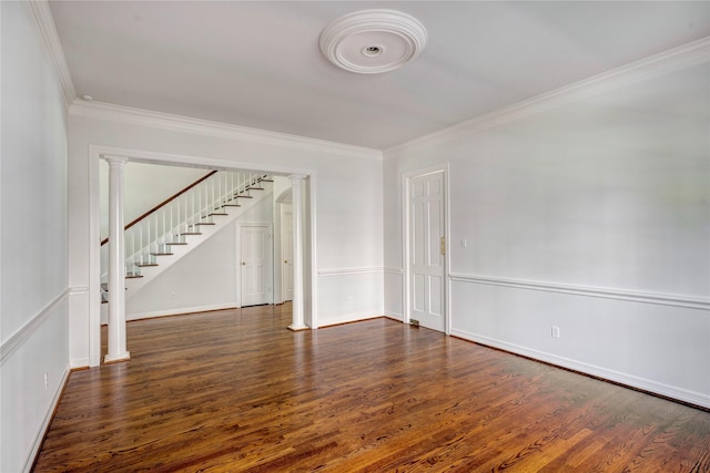 spare room featuring ornamental molding, stairway, ornate columns, and wood finished floors