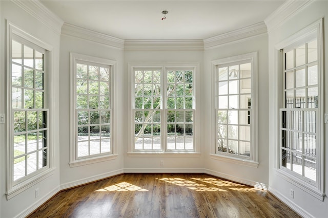 unfurnished sunroom featuring baseboards, ornamental molding, and wood finished floors