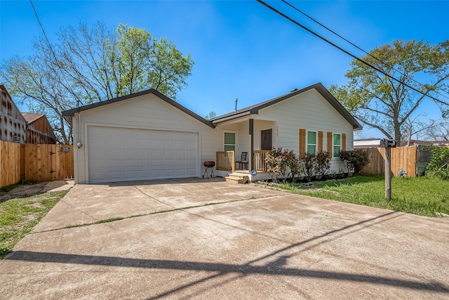 single story home featuring concrete driveway, a front yard, an attached garage, and fence