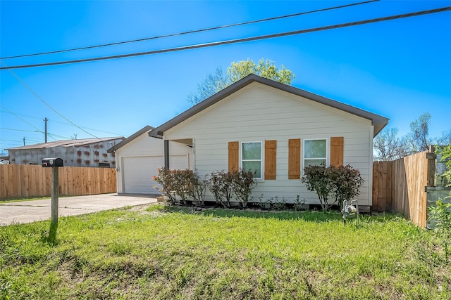 view of front of home featuring a front lawn, driveway, a garage, and fence