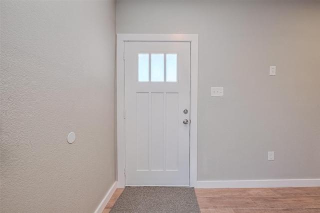 entryway featuring baseboards and light wood-type flooring