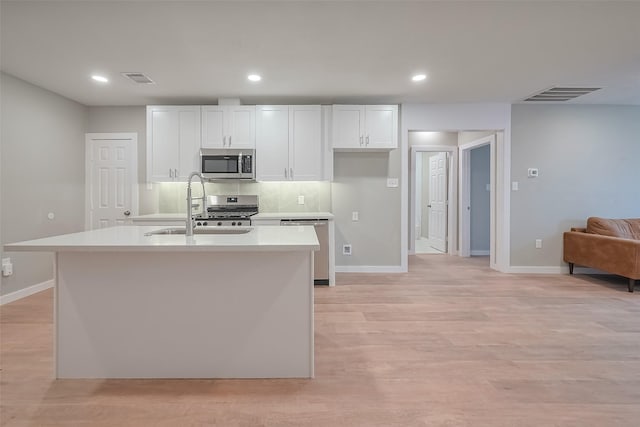 kitchen featuring stainless steel appliances, light countertops, a sink, baseboards, and visible vents