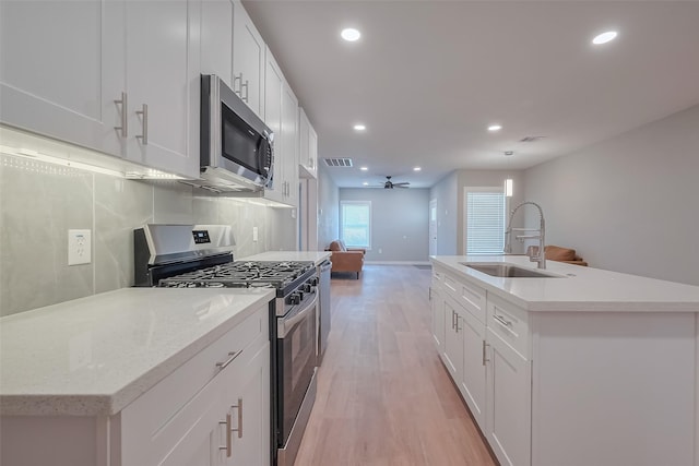 kitchen with appliances with stainless steel finishes, recessed lighting, a ceiling fan, and a sink