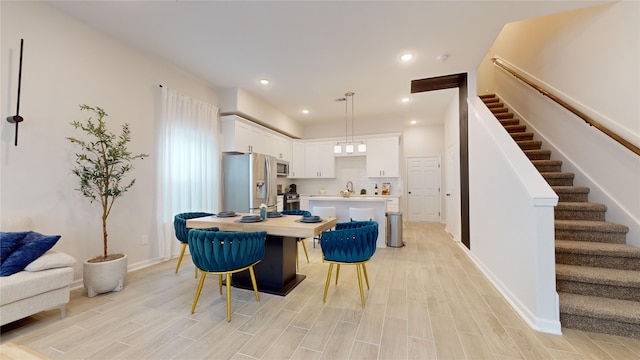 6211 Fairchild St, Houston, TX 77028 - kitchen with appliances with stainless steel finishes, a kitchen island, light countertops, white cabinets, and light wood-type flooring