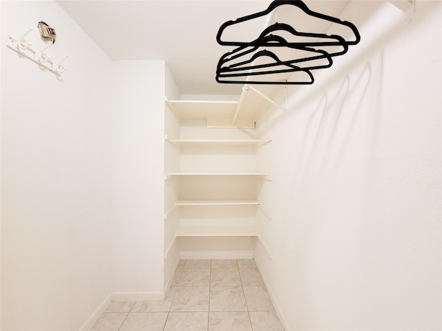 walk in closet with marble finish floor
