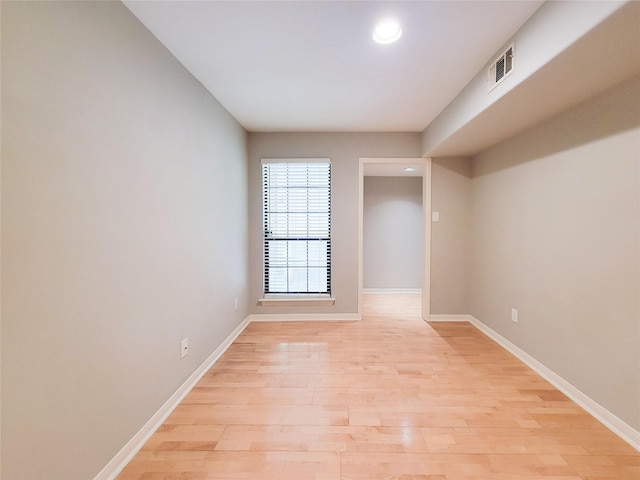 empty room featuring light wood finished floors, baseboards, visible vents, and recessed lighting