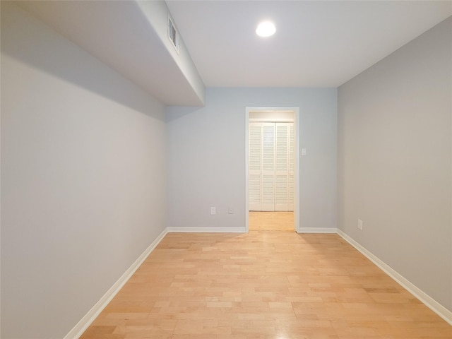 empty room featuring baseboards, visible vents, and light wood-style floors