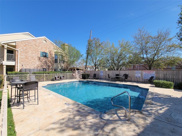 pool featuring fence and a patio area