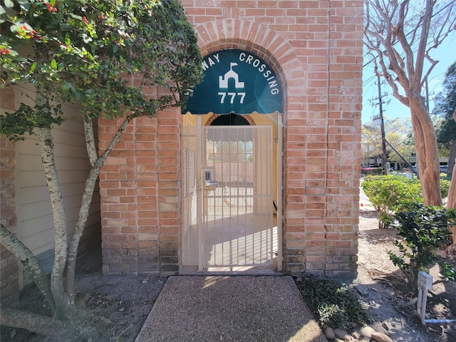 doorway to property featuring brick siding