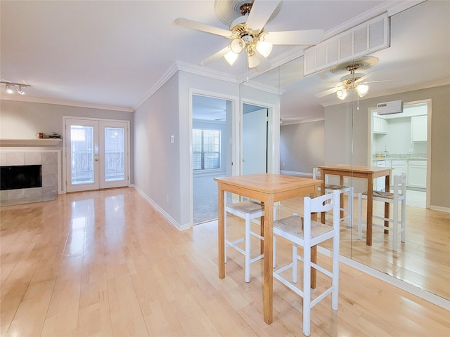 dining space featuring crown molding, a ceiling fan, light wood-type flooring, baseboards, and visible vents
