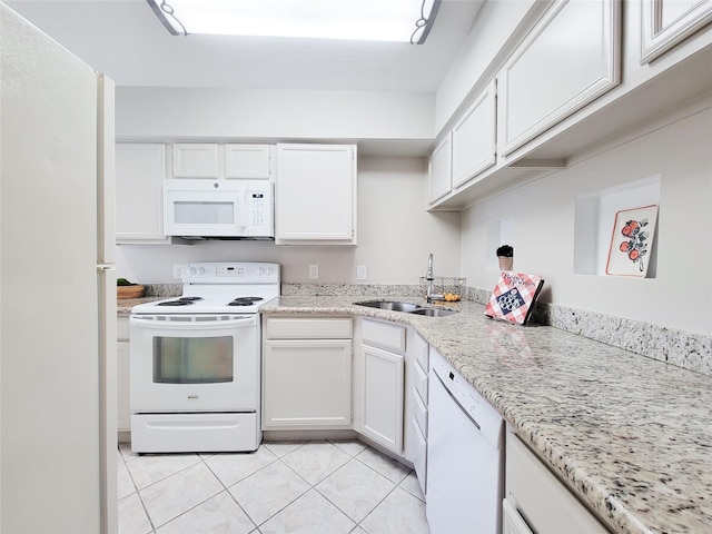 kitchen with light tile patterned flooring, light stone counters, a sink, white appliances, and white cabinets