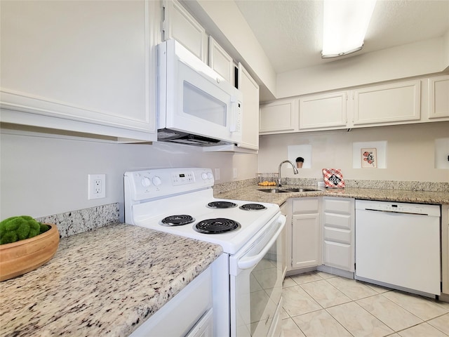 kitchen with light tile patterned flooring, white appliances, white cabinetry, and a sink