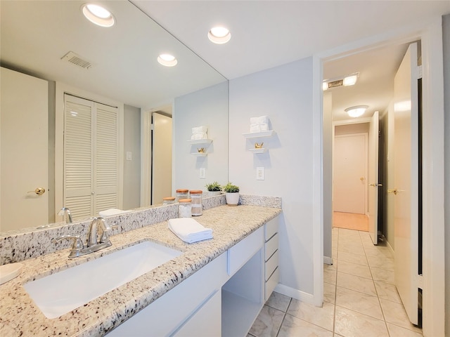 bathroom featuring a closet, visible vents, baseboards, recessed lighting, and vanity