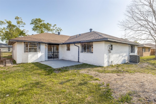 rear view of property with fence, brick siding, central AC unit, a patio area, and a lawn