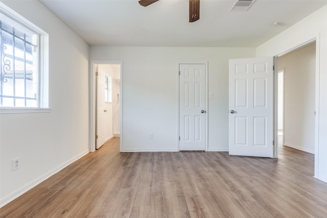 unfurnished bedroom featuring baseboards, a ceiling fan, wood finished floors, and visible vents