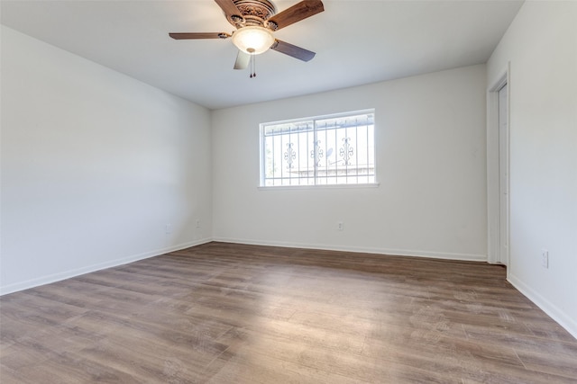spare room featuring baseboards, a ceiling fan, and wood finished floors