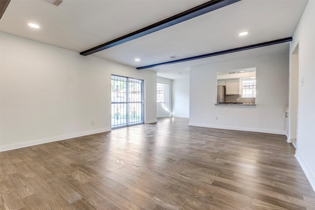 unfurnished living room with recessed lighting, baseboards, and wood finished floors