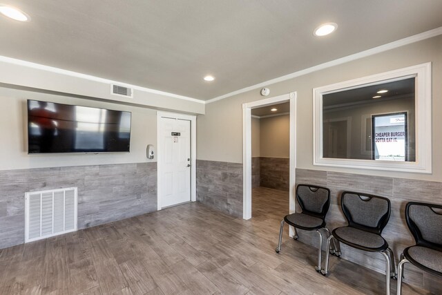 407 S Home St, Corrigan, TX 75939 - unfurnished room featuring visible vents, tile walls, wood finished floors, and a wainscoted wall