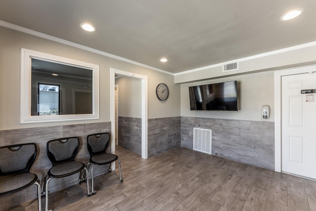 407 S Home St, Corrigan, TX 75939 - living area with visible vents, wainscoting, and wood finished floors