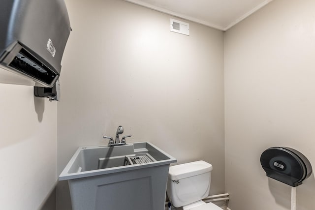 407 S Home St, Corrigan, TX 75939 - half bathroom with a sink, visible vents, toilet, and water heater