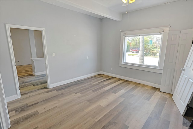 2025 Avenue N 1/2 Ave N 1/2, Galveston, TX 77550 - unfurnished bedroom with light wood finished floors, baseboards, and beamed ceiling