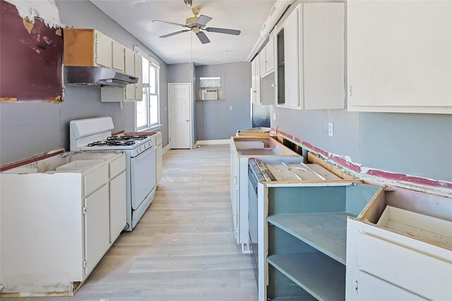 2025 Avenue N 1/2 Ave N 1/2, Galveston, TX 77550 - kitchen with under cabinet range hood, gas range gas stove, ceiling fan, light wood-style floors, and baseboards