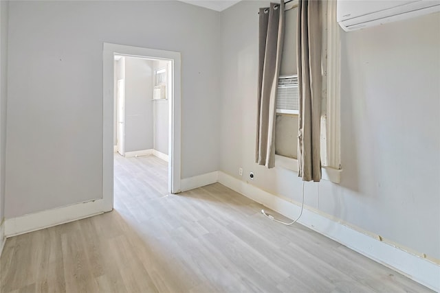 2025 Avenue N 1/2 Ave N 1/2, Galveston, TX 77550 - empty room featuring an AC wall unit, light wood-style floors, and baseboards