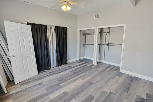2025 Avenue N 1/2 Ave N 1/2, Galveston, TX 77550 - unfurnished bedroom featuring wood finished floors, multiple closets, baseboards, and a ceiling fan