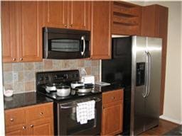 1711 Old Spanish Trl Unit 243, Houston, TX 77054 - kitchen featuring open shelves, tasteful backsplash, stainless steel refrigerator with ice dispenser, dark countertops, and electric range