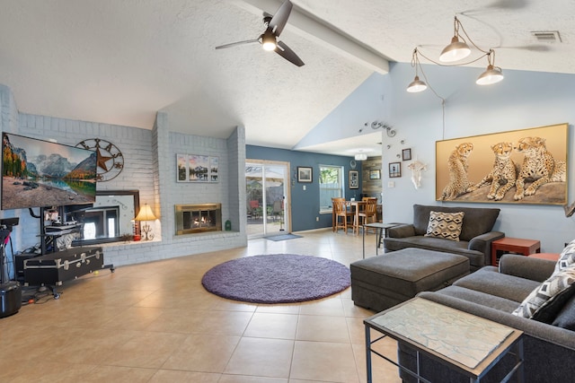 tiled living room with a textured ceiling, visible vents, a brick fireplace, ceiling fan, and vaulted ceiling with beams