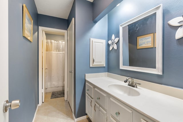 bathroom featuring baseboards, curtained shower, tile patterned flooring, and vanity