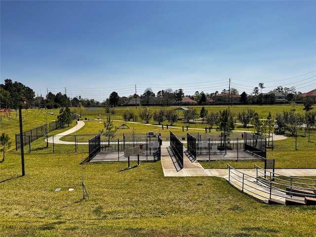 view of community featuring fence and a yard