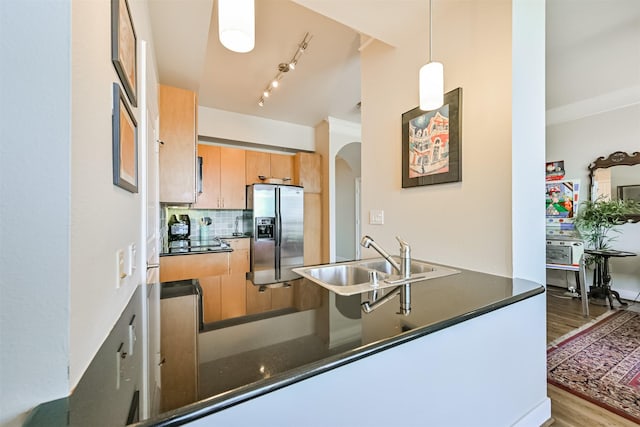 3333 Allen Pkwy Unit 1804, Houston, TX 77019 - kitchen featuring stainless steel fridge, dark countertops, arched walkways, a peninsula, and wood finished floors