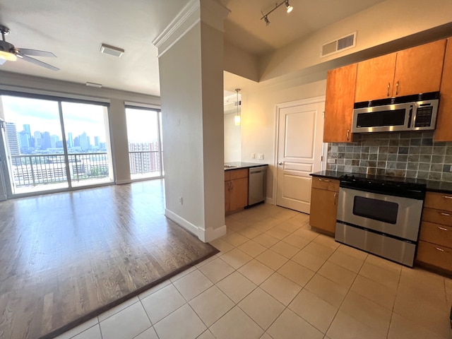 3333 Allen Pkwy Unit 1804, Houston, TX 77019 - kitchen with appliances with stainless steel finishes, open floor plan, dark countertops, ceiling fan, and tasteful backsplash