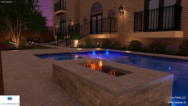 outdoor pool with a patio area and an outdoor fire pit