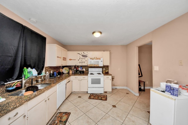 12041 Willow Trl, Houston, TX 77035 - kitchen with white appliances, tasteful backsplash, light tile patterned floors, dark stone counters, and white cabinets