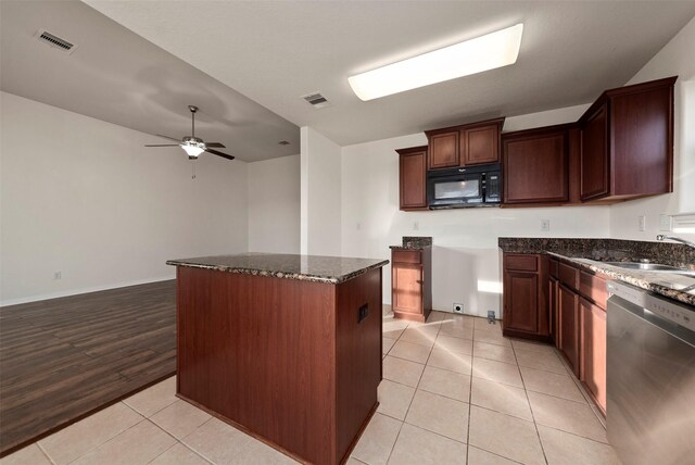 6906 Chessgate Falls Ln, Rosenberg, TX 77469 - kitchen with a sink, black microwave, dishwasher, dark stone countertops, and visible vents