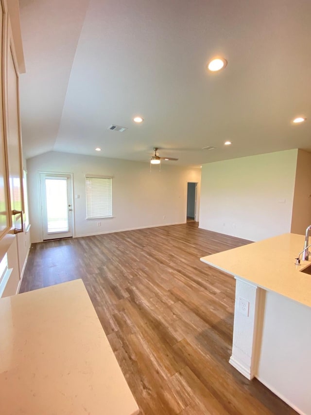 unfurnished living room featuring recessed lighting, ceiling fan, wood finished floors, visible vents, and lofted ceiling
