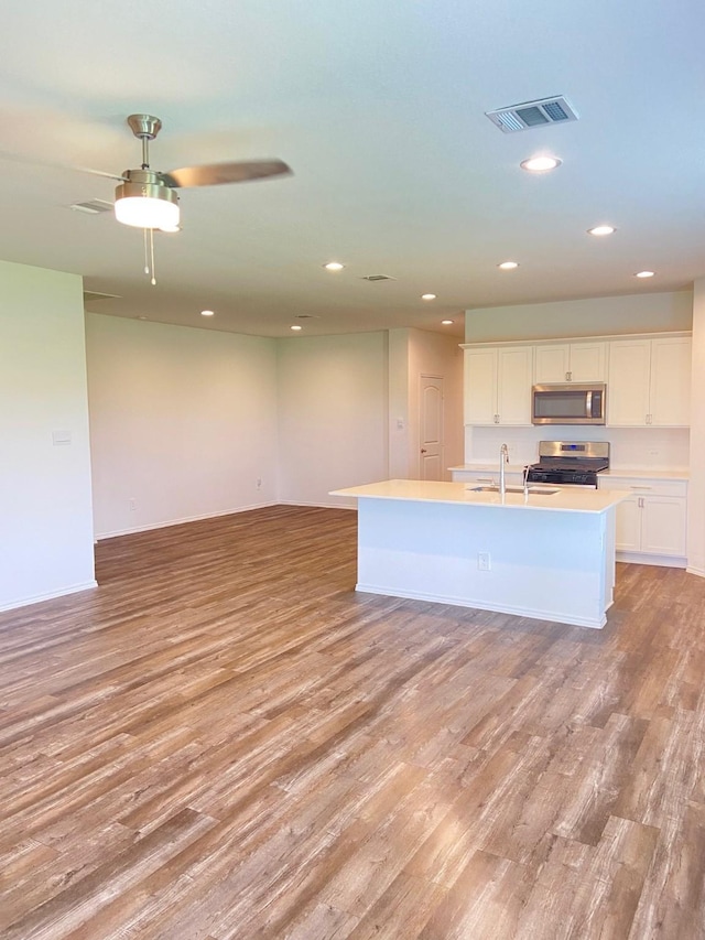 kitchen featuring appliances with stainless steel finishes, open floor plan, visible vents, and light wood-style flooring