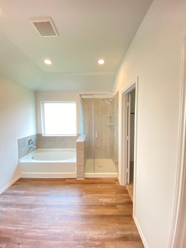 full bathroom featuring recessed lighting, wood finished floors, a bath, visible vents, and a stall shower
