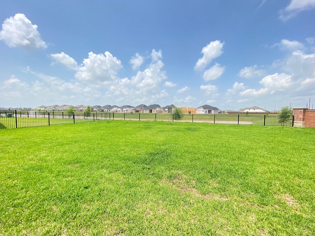 view of yard featuring fence and a residential view