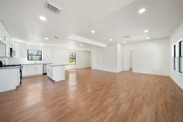 5610 Belarbor St, Houston, TX 77033 - unfurnished living room featuring light wood finished floors, visible vents, and a sink
